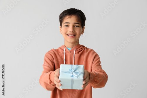 Little boy with gift on lig...