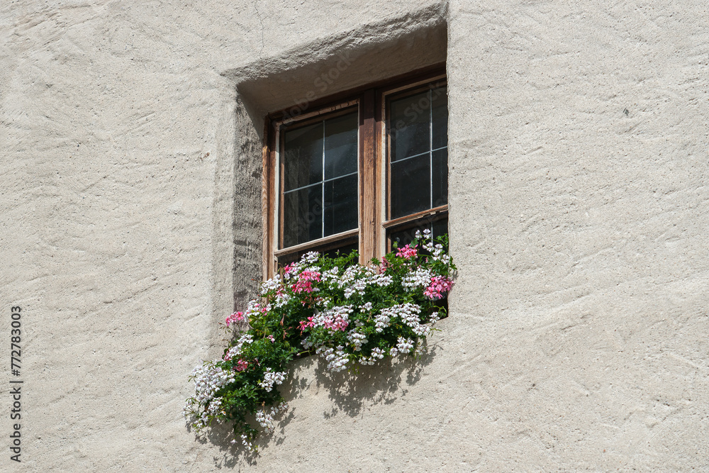 Fenster eines antiken Gebäudes mit Blumen davor