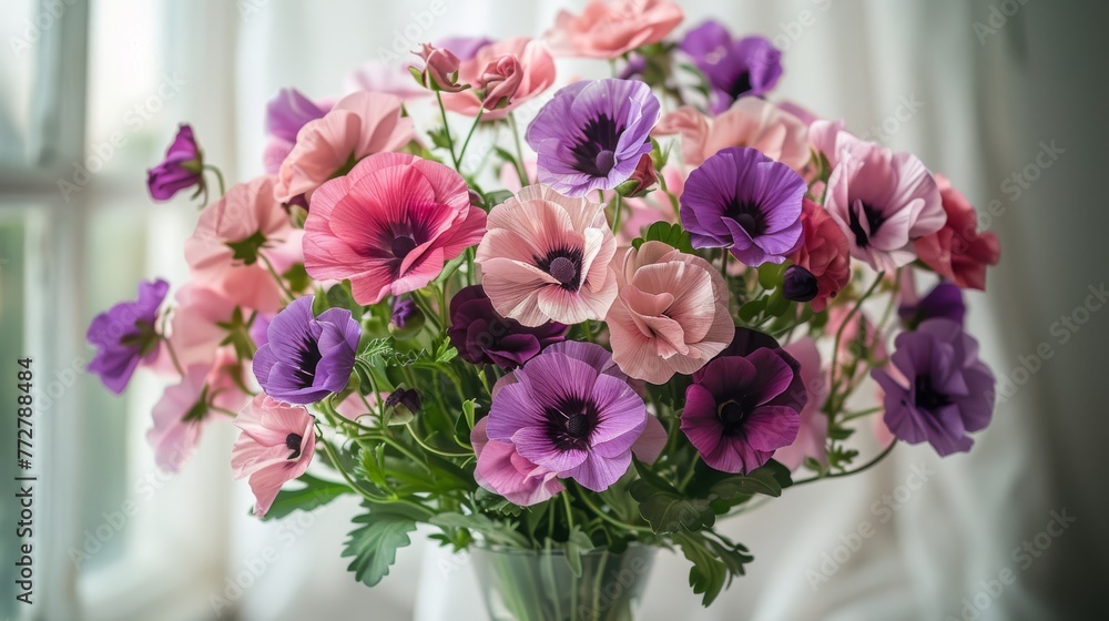   Pink & purple flowers in vase on window sill with white curtain backdrop