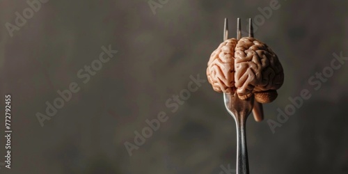 A metal fork with a piece of a human brain impaled on it, on a neutral background photo