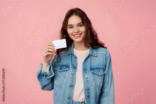 A young woman in a denim shirt holding a business card 