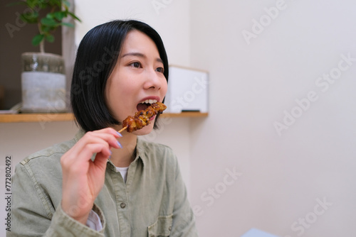 焼き鳥を食べる女性