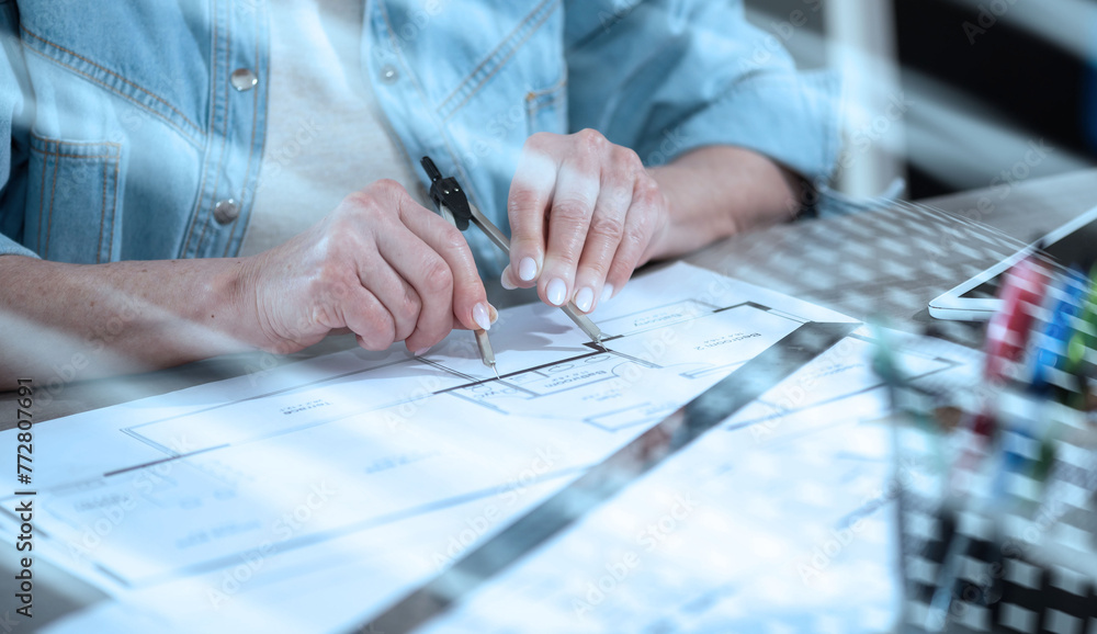 Female architect working on blueprint; light effect Female architect working on blueprint; light effect