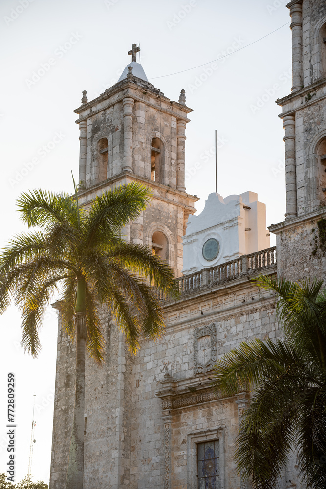Beautiful image of the cathedral of Valladolid in Mexico, surrounded by palm trees.