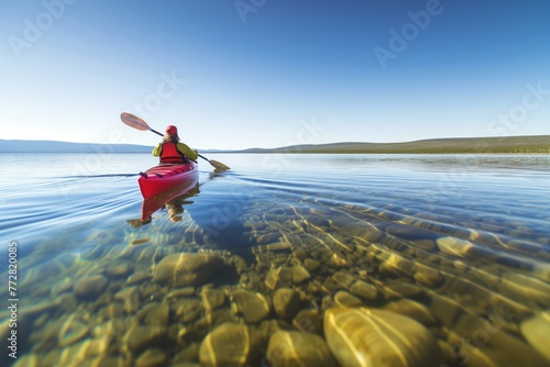 person kayaking on a clear and calm lake
