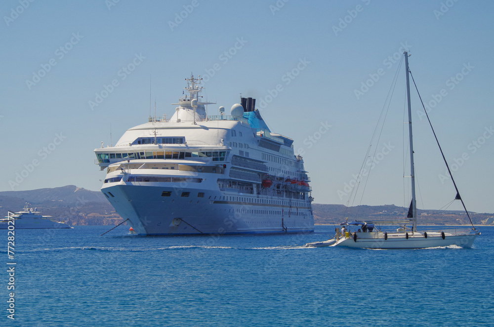 Small classic luxury cruiseship cruise ship liner yacht anchoring on Aegean blue sea in front of Milos Island during summer Mediterranean Greek isles cruising