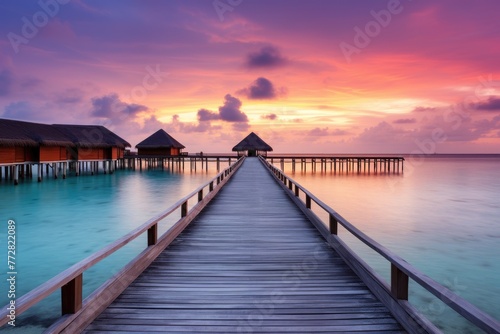 Wooden jetty at sunset in tropical  island with water bungalows An amazing sunset landscape Picturesque summer sunset , Ai generated © Tanu