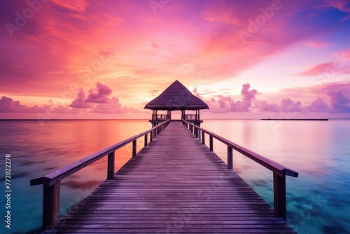 Wooden jetty at sunset in tropical Maldives island with water bungalows An amazing sunset landscape Picturesque summer sunset in the Maldives, Ai generated © Tanu