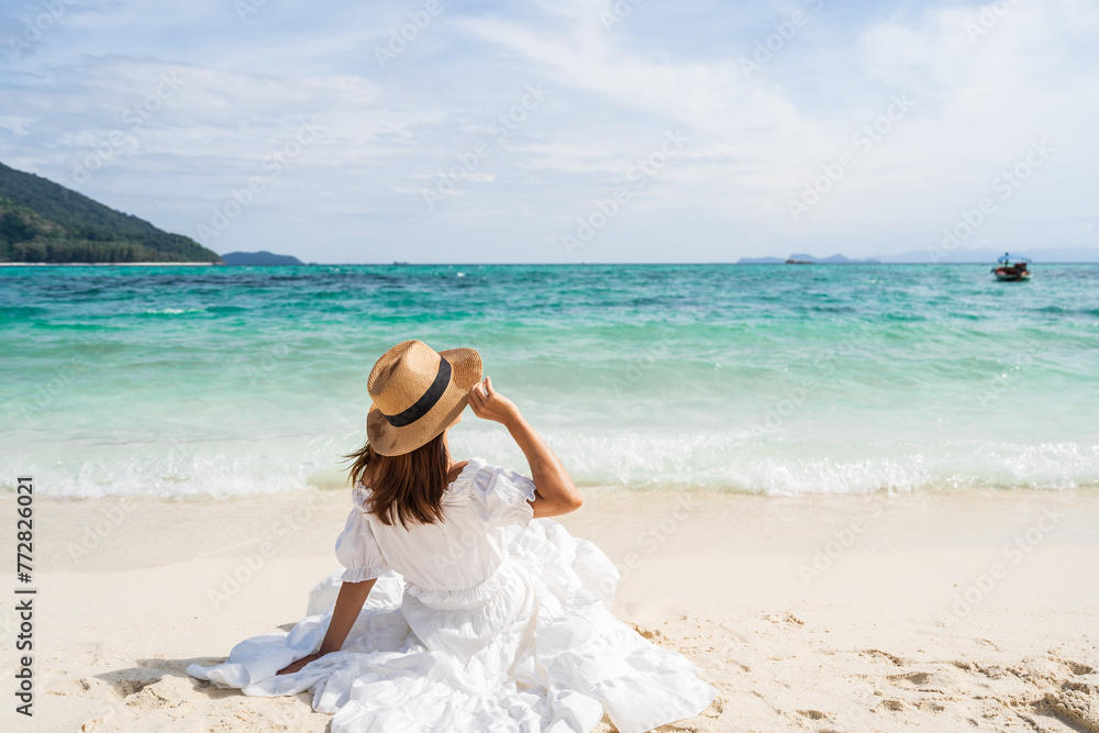 Young woman traveler sitting and relaxing at beautiful tropical white sand beach with wave foam and transparent sea, Summer vacation and Travel concept Young woman traveler sitting and relaxing at beautiful tropical white sand beach with wave foam and transparent sea, Summer vacation and Travel concept