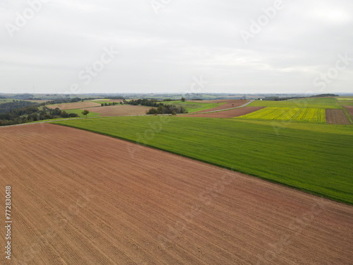 Aerial view of a farmland with country fields and a road 