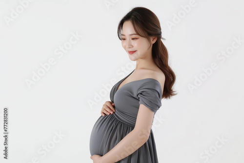 Side view of a full-term pregnant Korean woman in her early 30s, wearing a gray pregnant women, 100% white background, Place one hand on your stomach