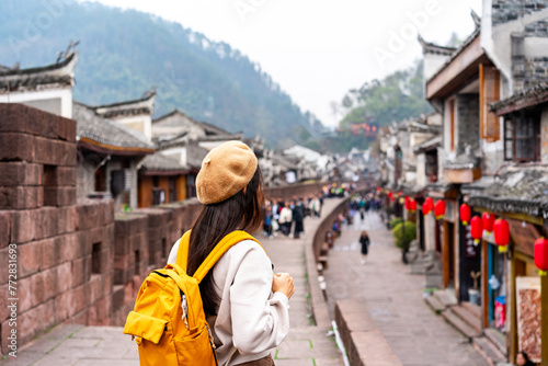 Young female tourist looking at the beautiful landscape of Feng Huang Ancient Town, The famous tourist destination at Hunan Province, China
