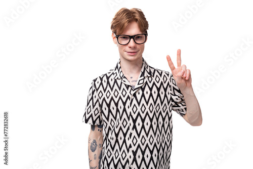 a young pleasant friendly caucasian ginger man with a tattoo on his arms is dressed in a black and white shirt with diamond print