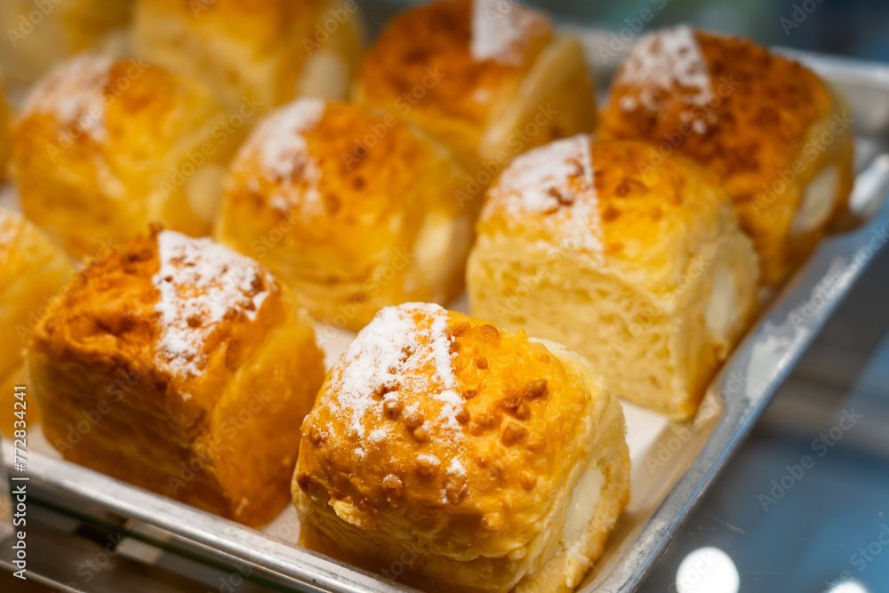 Lush buns sprinkled with powdered sugar in a beautiful bakery showcase Lush buns sprinkled with powdered sugar in a beautiful bakery showcase