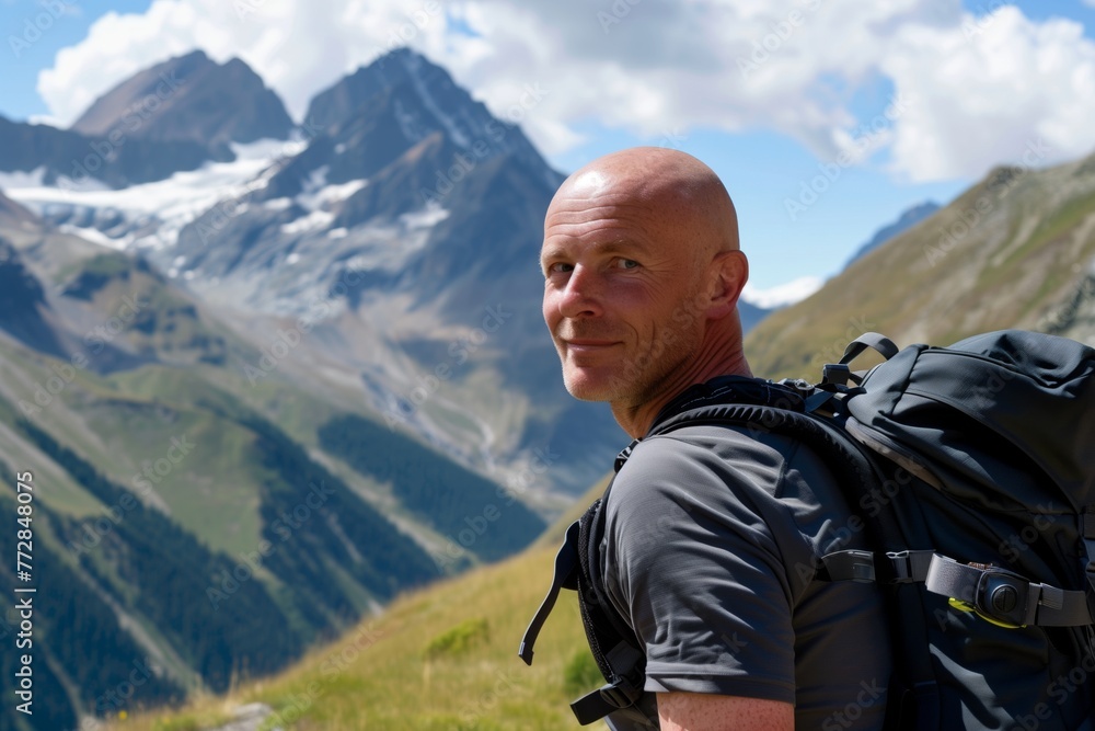 bald man with a backpack hiking in the mountains
