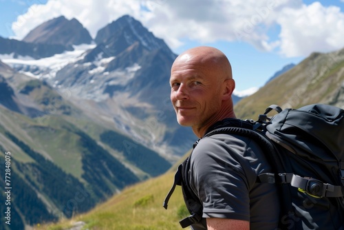 bald man with a backpack hiking in the mountains