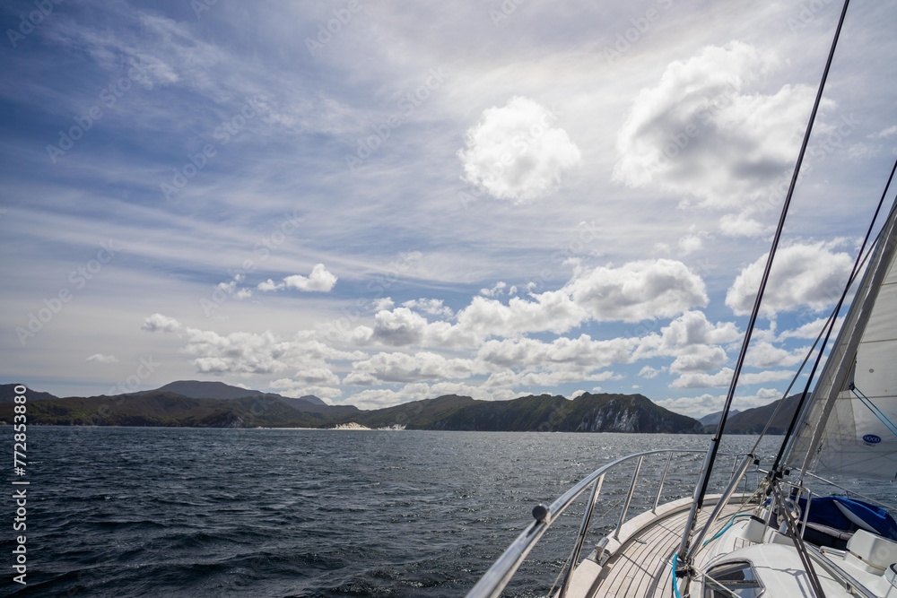 Fototapeta premium exploring the oceans and world while sailing a yacht with a sail on a beautiful day exploring the australian coastline of tasmania