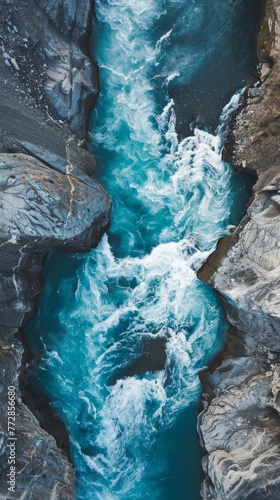 Aerial view of a turquoise river cutting through a rocky canyon