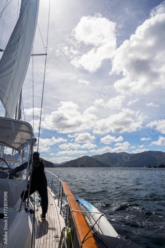 sailor sailing a yacht with a sail on a beautiful day exploring the australian coastline of tasmania