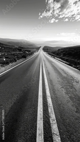 Black and white image of a long open road