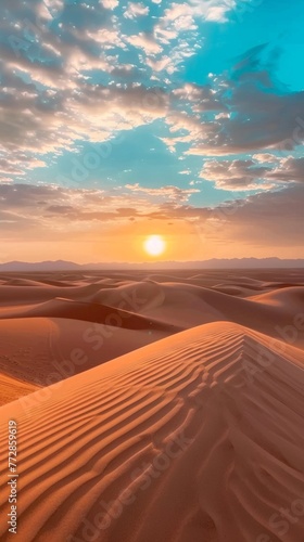 Sunset over desert dunes with cloudy sky