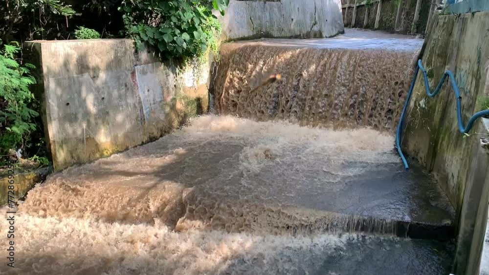 Brown river water flows rapidly after rain in Indonesia Brown river water flows rapidly after rain in Indonesia