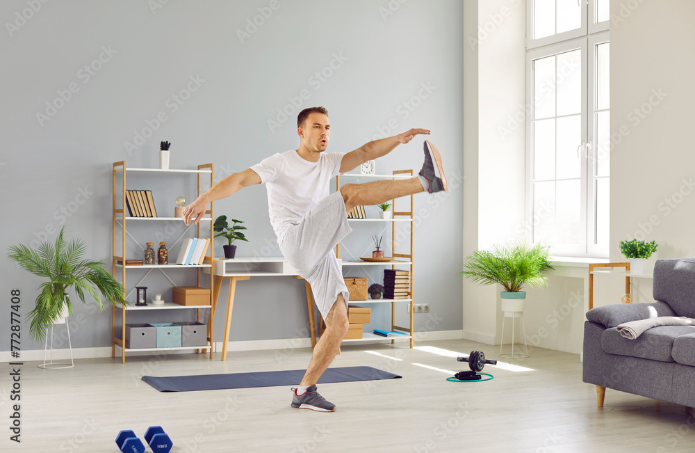 Full length portrait of a sporty athletic young man exercising at home on the floor. Young guy doing sport exercises in the living room. Fitness, healthy lifestyle and home training concept. Full length portrait of a sporty athletic young man exercising at home on the floor. Young guy doing sport exercises in the living room. Fitness, healthy lifestyle and home training concept.