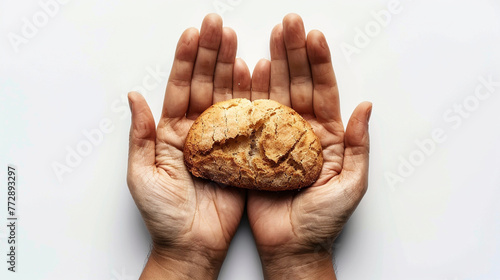 A pair of hands, palms up, holding a dry crust of bread against a stark white background, embodying the struggle against hunger and poverty.