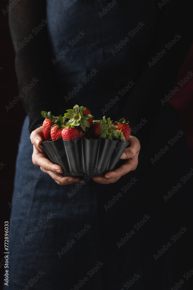 Delicious, ripe, red strawberries in a metallic bowl against a black background Delicious, ripe, red strawberries in a metallic bowl against a black background