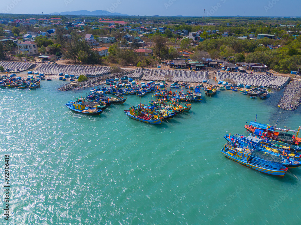 Aerial view of Loc An fishing village, Vung Tau city. A fishing port with tsunami protection concrete blocks. Cityscape and traditional boats in the sea.