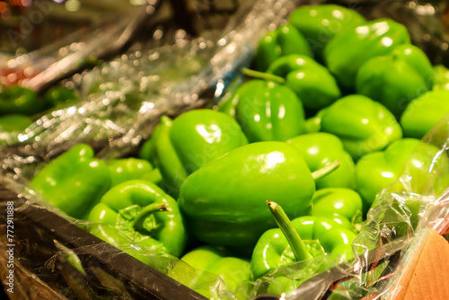 Green bell peppers, half and half composition. A few fresh green peppers on burlap on a wooden table. Fresh green peppers variety dolma. Low key, close-up. Green peppers boxes. Raw and organic. photo
