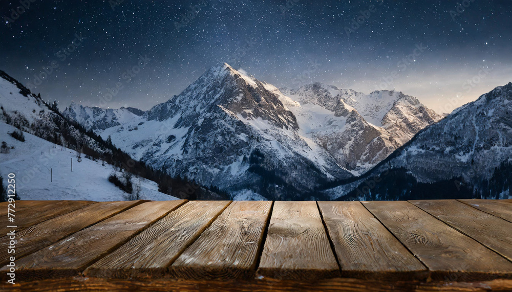Empty wooden deck table against view of snowy mountain range in the night. Empty wooden deck table against view of snowy mountain range in the night.