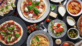Full table of italian meals on plates Pizza, pasta, ravioli, carpaccio