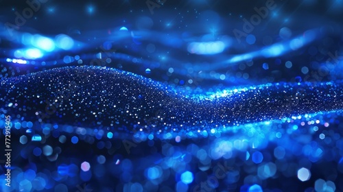 Shiny blue glitter in an abstract, defocused background with blurry lights shining through