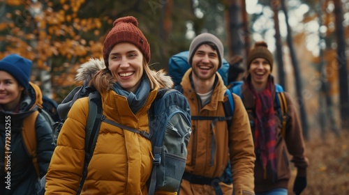 Group of smiling friends walking through woods with backpacks - adventure, travel, tourism, hike and people concept