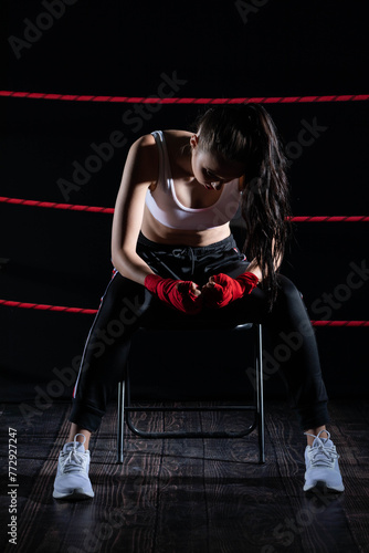 The athlete sits in a chair in the boxing ring after losing the fight. Despite the technical preparation, the athlete lost the fight. © fotodrobik