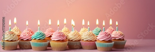 Colorful cupcakes with lit candles are displayed against a pink background, indicating an indoor celebration event marking of joy and celebrating. with free space