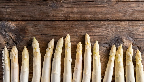 weißer Spargel auf Holzhintergrund am unteren Rand, textfreiraum draufsicht  photo