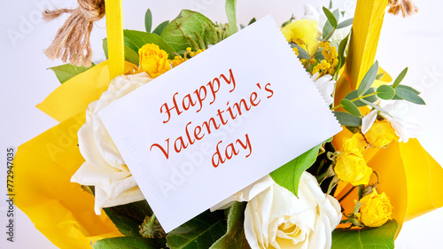 Happy Valentine's day text on a white leaf on a bouquet of bright beautiful flowers