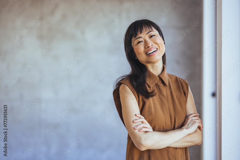 Doing business with a smile. Waist up shot of beautiful professional woman smiling towards camera in office corridor, elegance, intelligence, working.