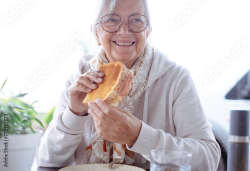 Fotografía Face of an elderly Caucasian woman with gray hair smiling while preparing to eat