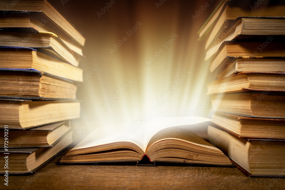 Fototapeta premium Old Book With Magic Lights On Vintage Table