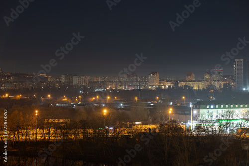 Night cityscape of the big city. Bright, multi colored light on empty streets. Apartment buildings in bedroom town area. Kyiv in end of march 2024. Ukraine.