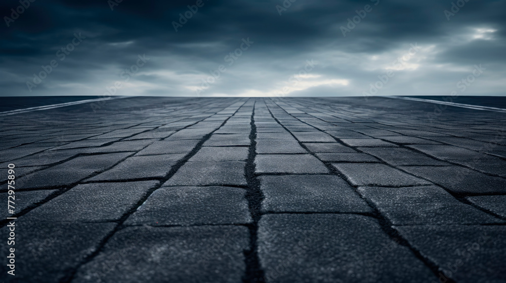 A dark sky with clouds over a brick road