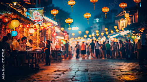 People strolling under hanging lanterns in the street at night