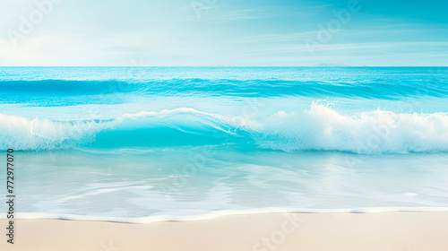 Wave approaching sandy beach under clear blue sky