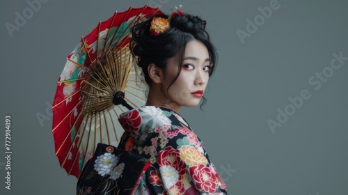 Japanese woman in a traditional kimono on grey background. Female in asian clothes. 