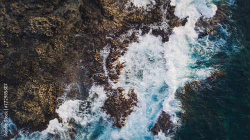 View from drone of Atlantic ocean with strong swell beating against the rocky cliff in Tenerife south coast, blue rough sea with big waves with foam crashing against the rocks, Canary island © luciano