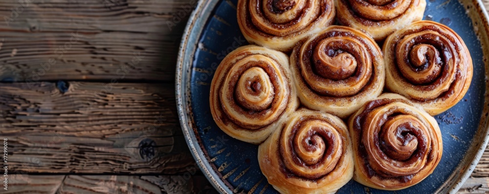 Freshly baked cinnamon rolls on a blue plate Freshly baked cinnamon rolls on a blue plate