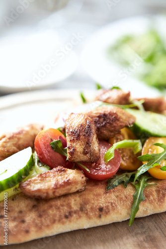 Pita bread with Chicken Breast, Cherry Tomatoes, Cucumber and Rocket. Close up.	